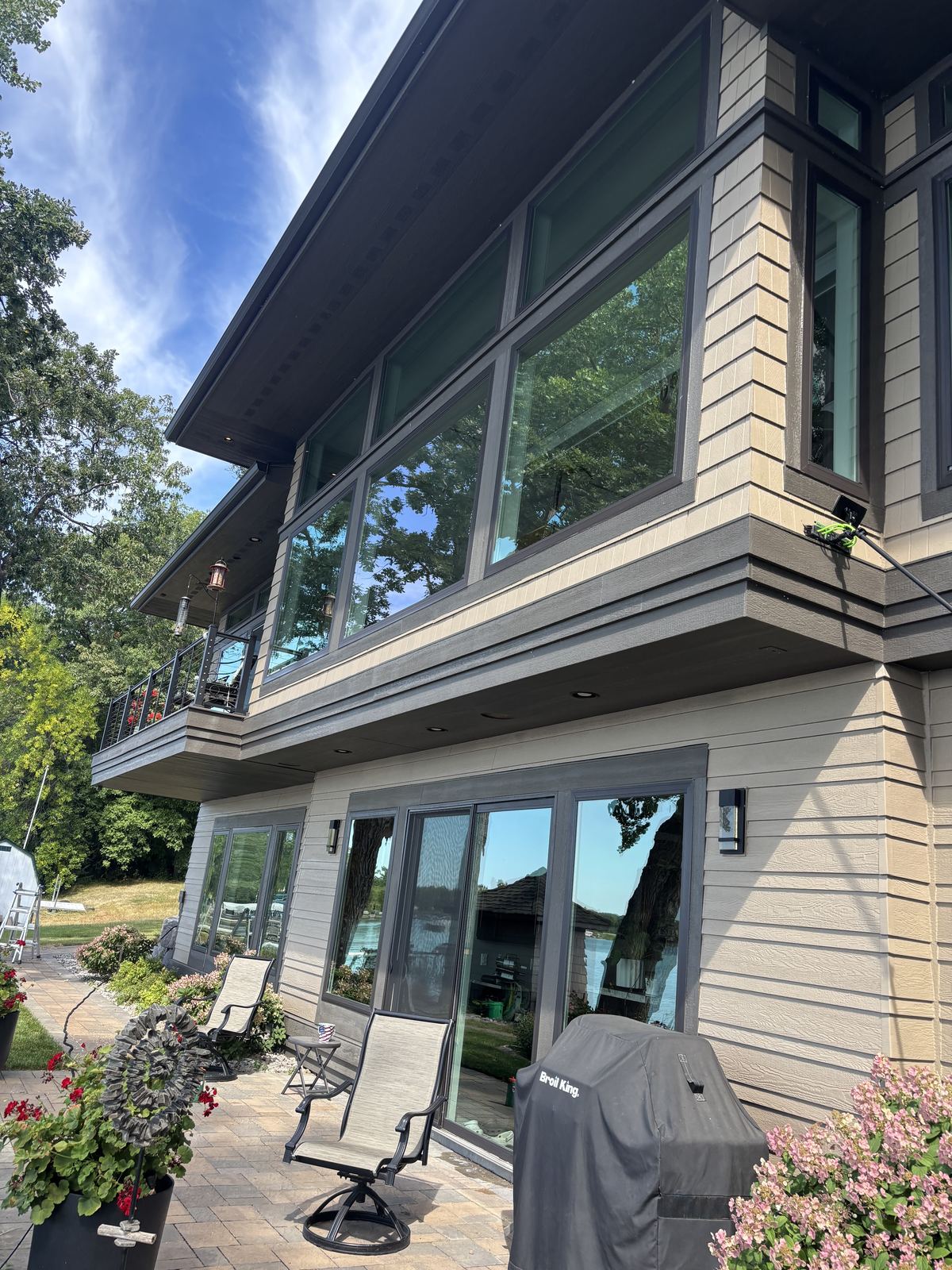 Water-fed pole cleaning the upper-level windows of a Buffalo lake home