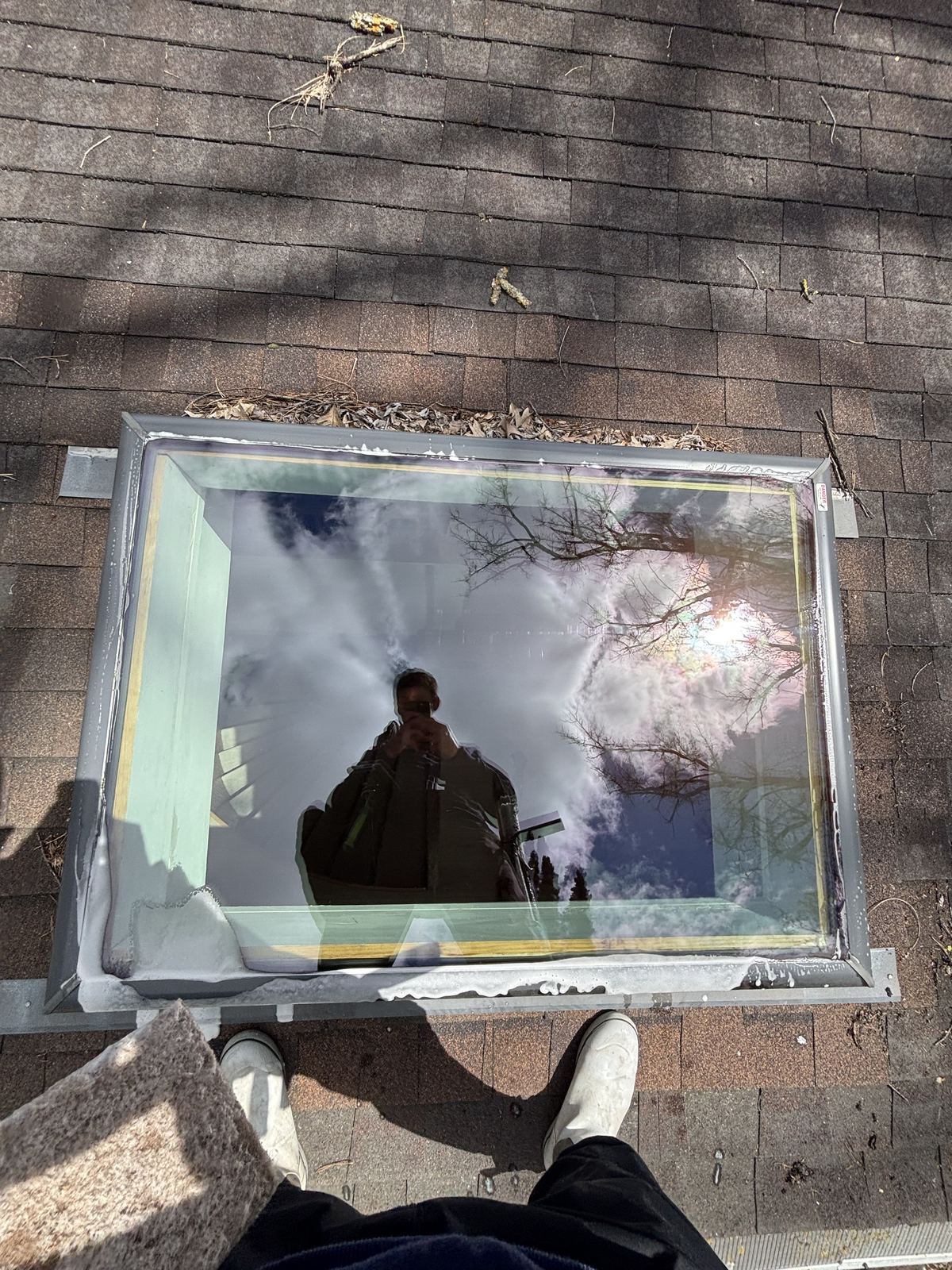 A skylight cleaned from the roof of a Plymouth home, with the sky reflected in the glass
