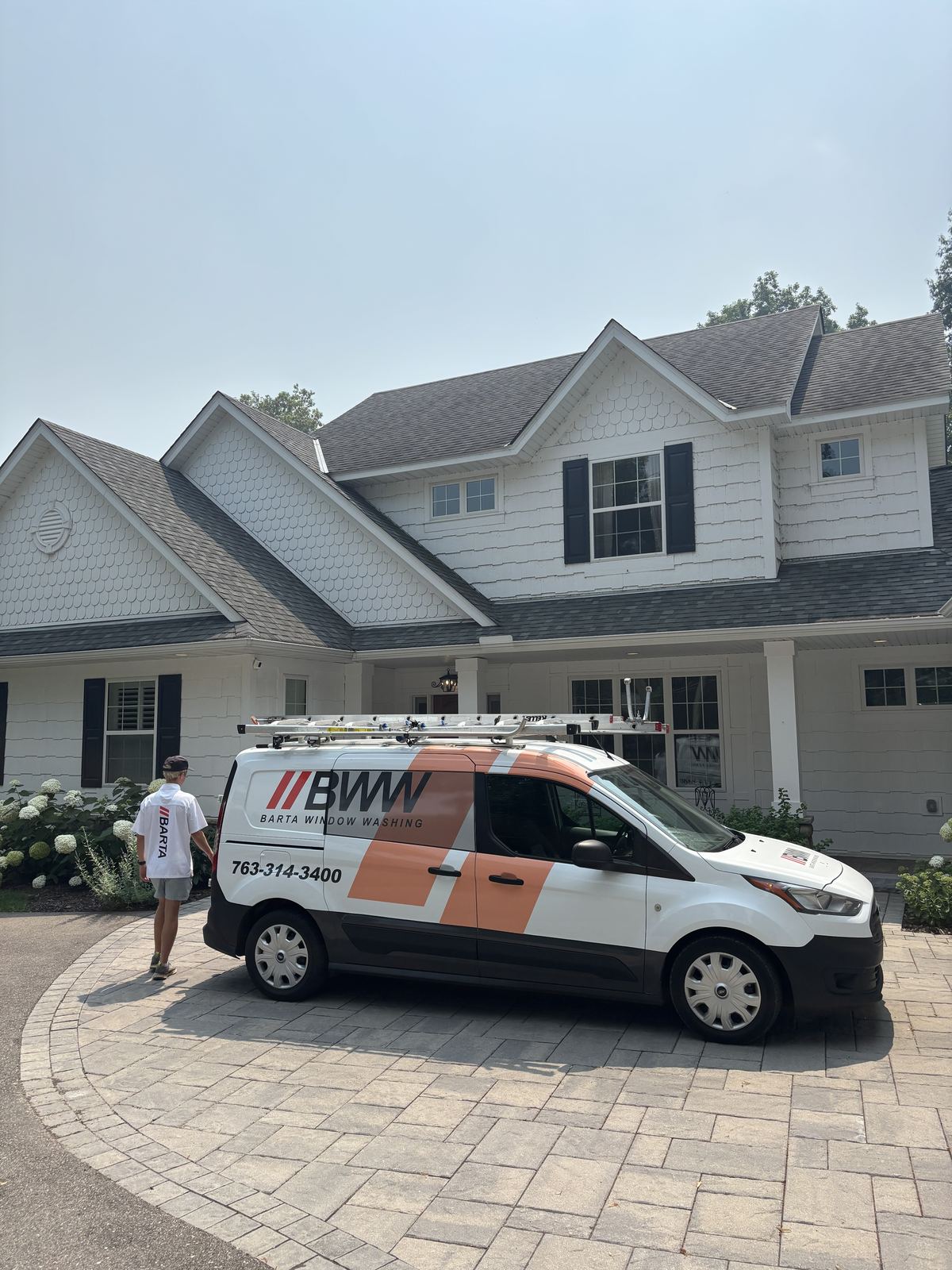 Barta Window Washing technician and van arriving at a Wayzata home for an exterior window cleaning