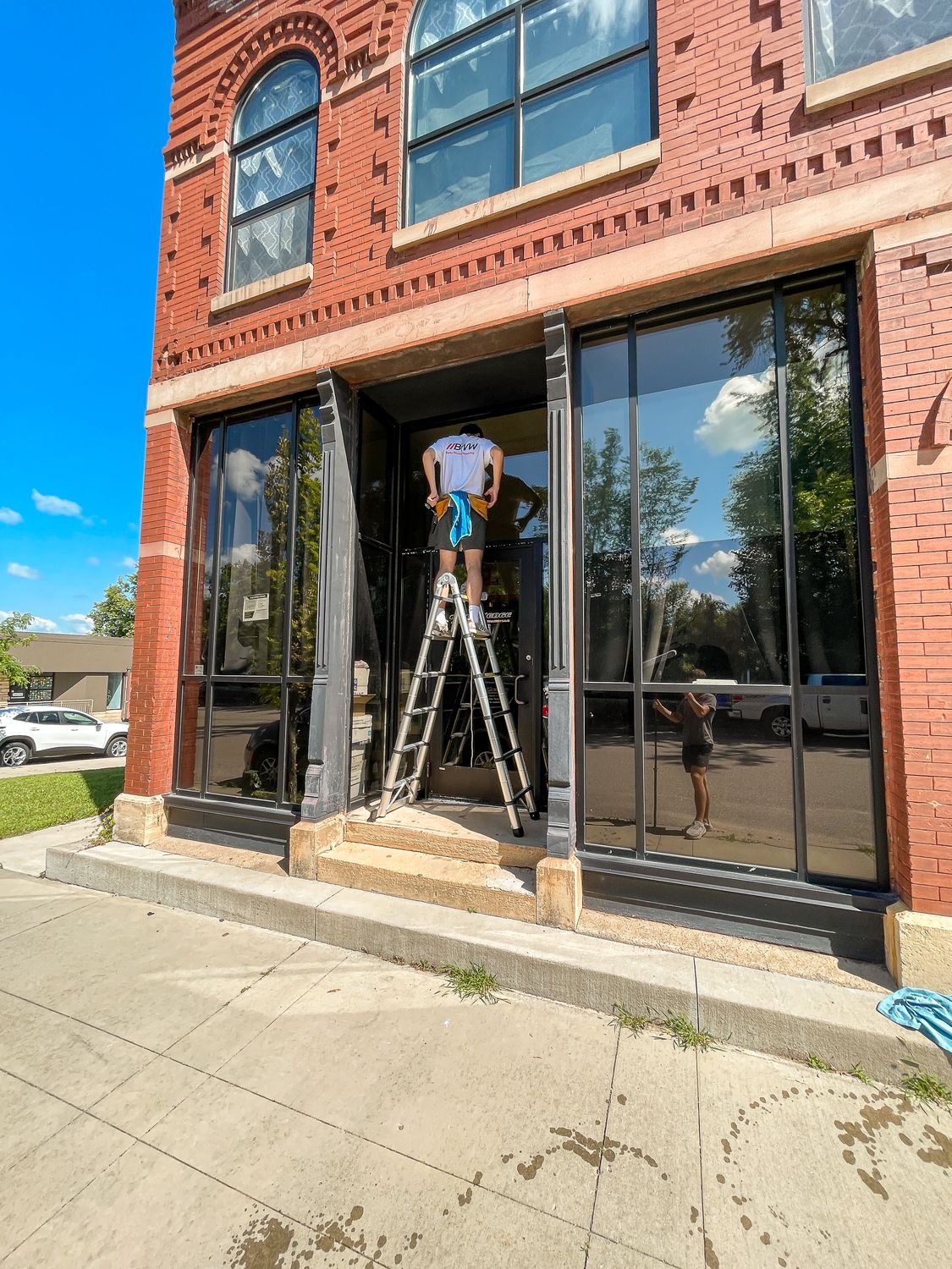 Technicians cleaning storefront windows on a commercial building