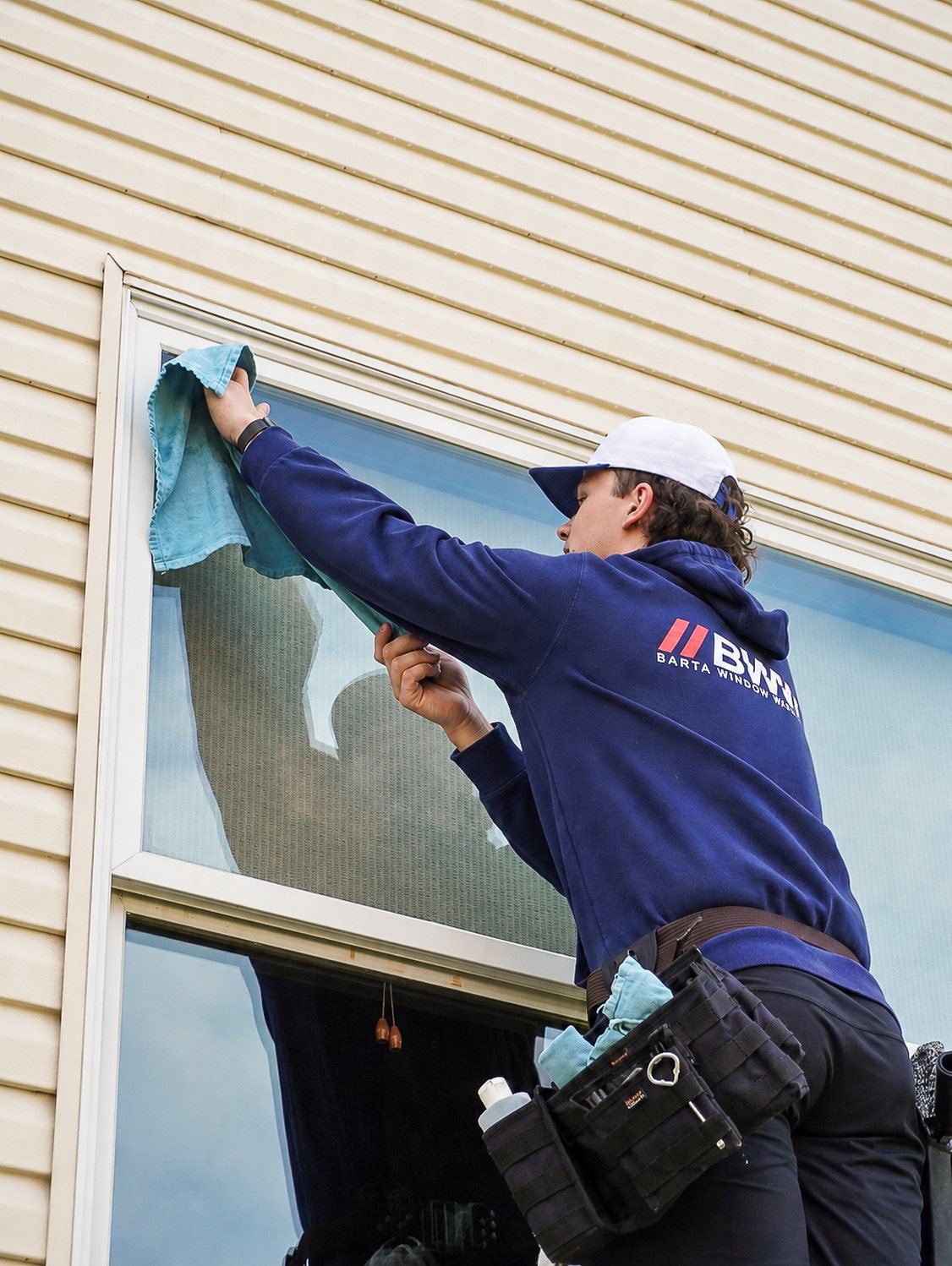Hand-detailing a window frame with a microfiber cloth